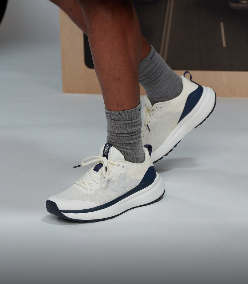 Knee-down shot of man wearing white and navy blue WK500 walking shoe
